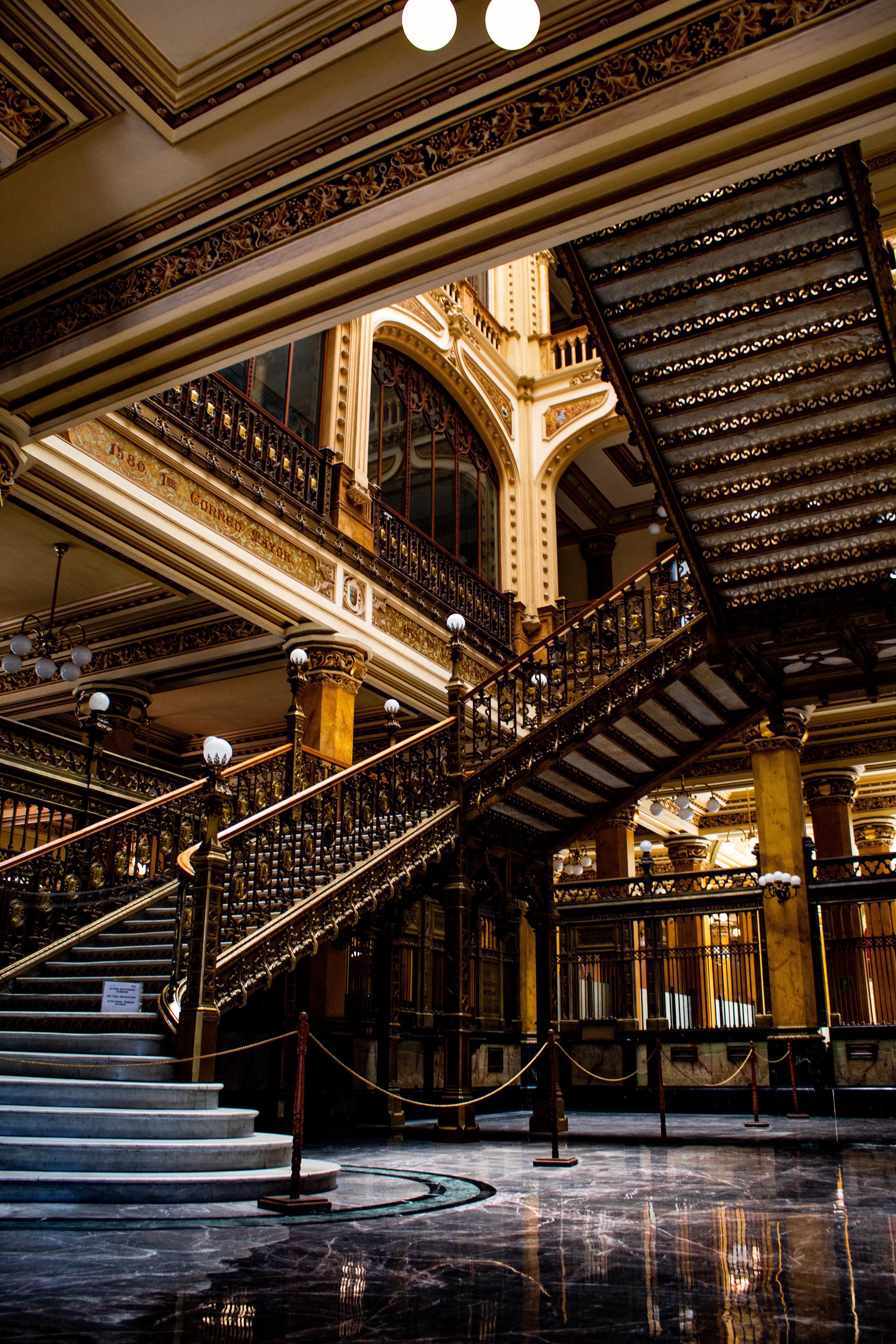 Prunkvolle historische Schwungtreppe mit dunklem Marmor, Messing und Kassettendecke